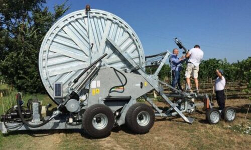 Un paio di uomini stanno regolando il getto di un irrigatore